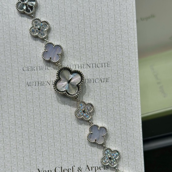 Van Cleef & Arpels watch with silver dial, diamond-set clover motif, and white mother-of-pearl.